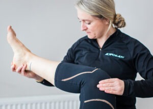 Physiotherapist holding a client's leg up and manipulating knee movement