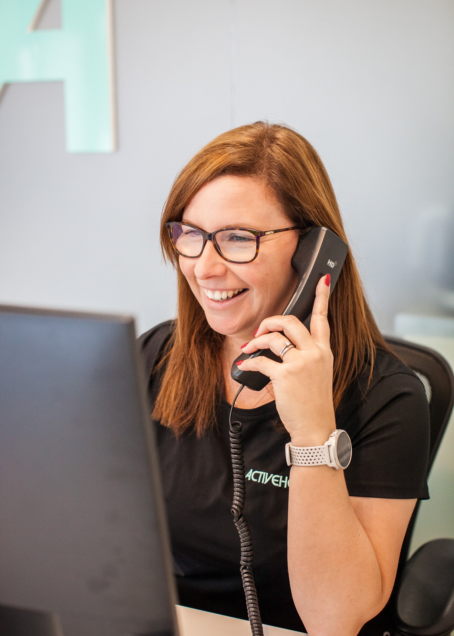 receptionist smiling on the phone whilst talking to a happy customer - booking a Free Discovery Visit